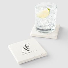 a marble coaster with a lemon slice on it next to a glass of water and ice