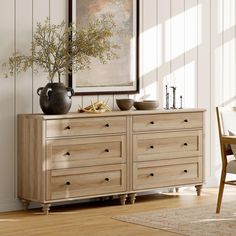 a wooden dresser with two vases on top of it