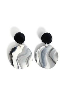 a pair of black and white earrings on a white background