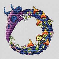 a cross stitch pattern with an image of a blue bird and flowers in the shape of a circle