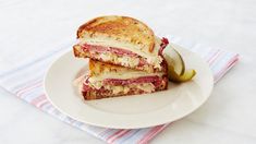 a cut in half sandwich sitting on top of a white plate next to a lemon wedge