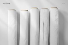 four rolls of white paper lined up against a wall