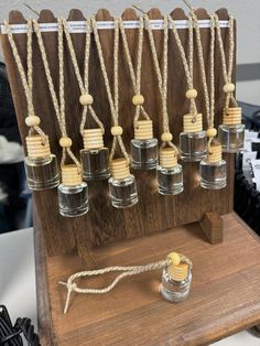 an assortment of small glass bottles with wooden caps on a display stand in front of other items