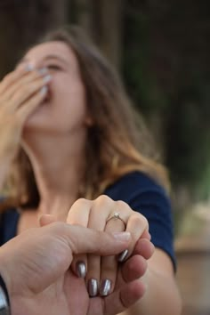 a man and woman holding hands while looking at each other's eyes with their fingers