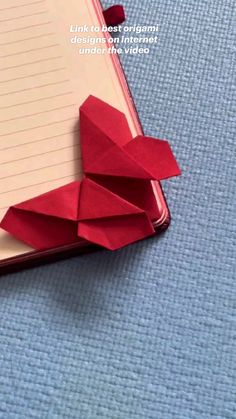 an open notebook with red origami on it