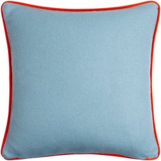 a blue and orange pillow with red piping on the front, sitting against a white background