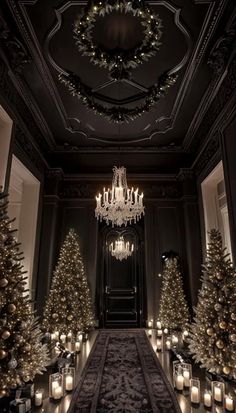 a room filled with lots of lit candles and christmas trees in front of a chandelier