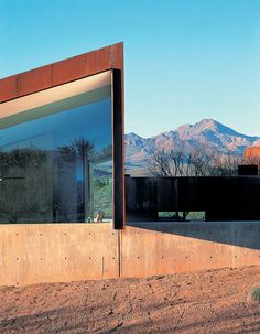 a large mirror on the side of a building with mountains in the backround