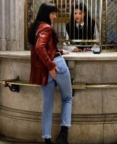 a woman standing in front of a window next to a man