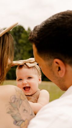 a man holding a baby in his arms with a hat on it's head