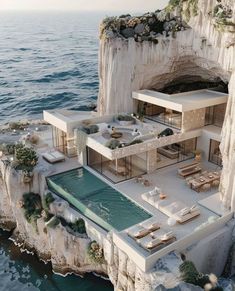 an aerial view of a house on the edge of a cliff overlooking the ocean and cliffs