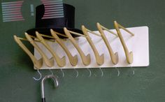 a hat and several pairs of scissors hanging on a rack with hooks attached to it