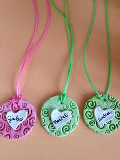 three ceramic ornaments with the names gujuelo and an embossed heart on them