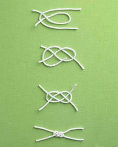 four pieces of white string tied together on a green surface with two pairs of scissors next to each other