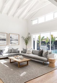 a living room filled with furniture and large windows