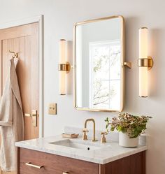 a bathroom with a sink, mirror and towel hanging on the wall next to it