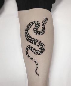 a black and white snake tattoo on the leg