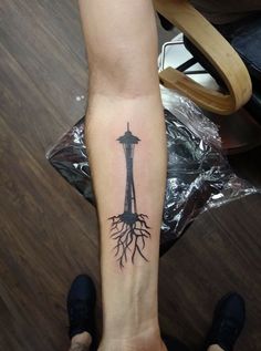 a person's foot with a tattoo on it and a tower in the background