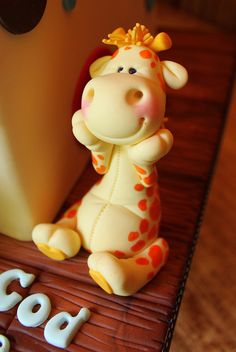 a cake shaped like a giraffe sitting on top of a wooden table next to the word god