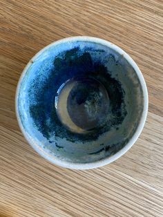 a blue and white bowl sitting on top of a wooden table