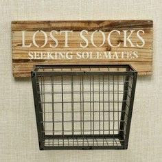 a wooden sign that says lost socks seeking solimaits hanging on the wall next to a wire basket