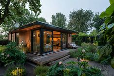 a small wooden house surrounded by greenery and trees