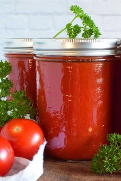 tomatoes and parsley sit next to two jars of tomato sauce