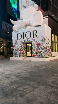 a building with a giant white bow on it's front and the word dior painted on its side