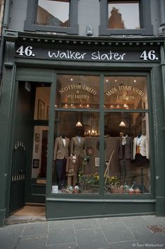 a store front with clothes on display in the window