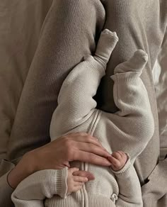 a woman is holding her baby while sitting on the couch with their arms around each other