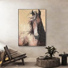 a horse painting hanging on the wall next to a wooden bench and table with a potted plant