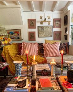 a living room filled with lots of furniture and candles on top of a coffee table