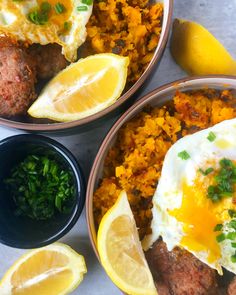 three bowls filled with different types of food on top of a table next to lemon wedges