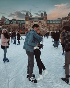 two people standing in the snow hugging each other