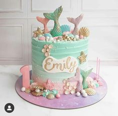 a birthday cake decorated with mermaid themed decorations