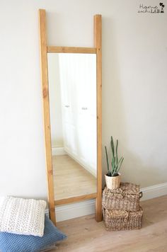 a mirror sitting on top of a wooden floor next to a plant