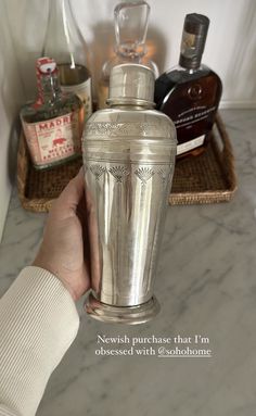 a person holding an old fashioned cocktail shaker