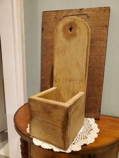 a wooden box sitting on top of a table next to a white lace doily