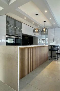 a modern kitchen with white cabinets and wooden slats