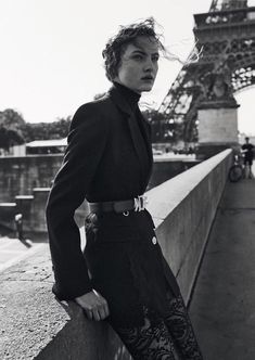 black and white photograph of woman in front of the eiffel tower