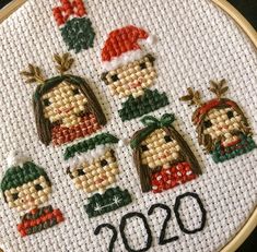 a cross stitch christmas ornament with the year 2020 written on it and four people in hats