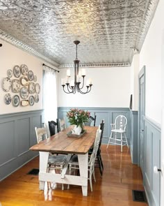 an instagram photo of a dining room with blue painted walls and wood flooring