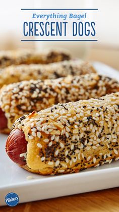 two hotdogs with sesame seeds and ketchup are on a white plate