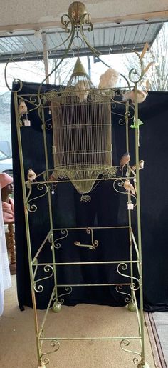 a birdcage is sitting on top of a stand