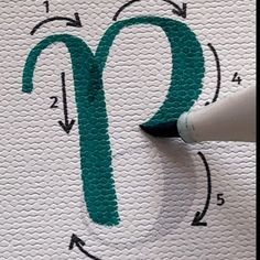 someone is drawing the letter o on a piece of white paper with green ink and a marker