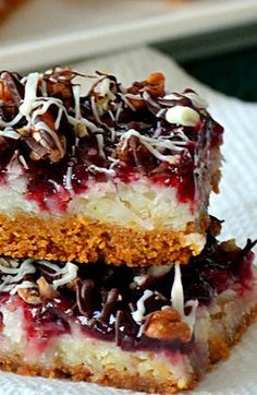 two pieces of cake sitting on top of each other with nuts and cranberry toppings