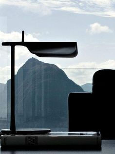 a chair and table in front of a window with a view of the mountains outside