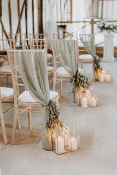 candles are lined up on the floor in front of chairs