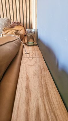 there is a glass sitting on the edge of a bed that has been made into a headboard