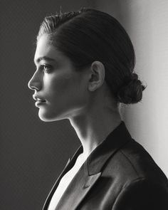 a black and white photo of a woman in a suit looking off into the distance